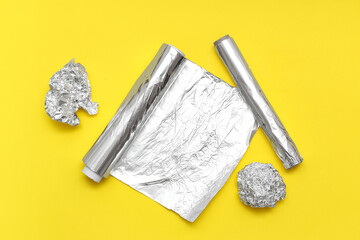 Canvas Print - Aluminium foil rolls with crumpled sheets on yellow background