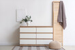 © Pixel-Shot - Folding screen, chest of drawers with eucalyptus branches in vase near white wall in room