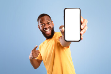 Wall Mural - mobile app advertisement. excited african american man pointing at smartphone with empty screen on b