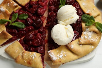 Wall Mural - Tasty galette with cherries and ice cream on white table, closeup