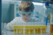 © Dmitriy - Little boy in protective goggles sitting at a chemistry lesson at a desk with flasks and beakers and conducting experiments.
