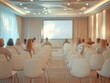 © jannoon028 - Audience Members Attend a Conference or Seminar Sitting in Chairs Facing Presentation Screen