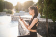 © Charlie's - Happy Active healthy asian woman use mobile cell phone exercising with smartphone at urban street outdoors fitness and phone