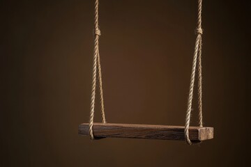 Poster - Isolated wooden swing suspended against a blurred brown backdrop