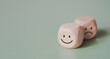 © LAONG - Wood cube with smile and sad icon, World mental health day or feedback rating concept, Positive customer review, Wood cube stacking with emotion face icon on pastel green background