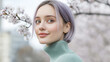 © Ari - Purple hair Woman in blue ribbed necks enjoy fresh air in park with cherry blossom