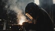 © Otseira - A welder in protective gear is busy working with a welding torch on a piece of metal, creating sparks and fusing the materials together