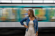 © Cavan - Confident woman posing in front of a moving Paris metro.
