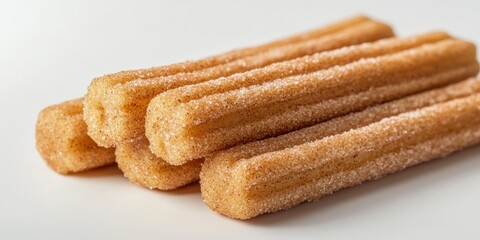 Wall Mural - Golden churros coated in sugar and cinnamon on a white background.