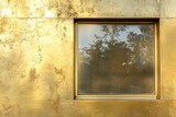 Square window reflects foliage in a golden shimmering wall