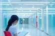 © AHNH5 - Young Woman Reading in a Modern Hallway with Bright Lighting