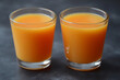 © Андрій Лис - Freshly squeezed carrot juice boasting health benefits served in clear glasses on a dark background