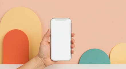 a person is holding a white cell phone in front of a colorful background