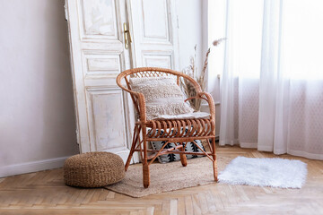 Wall Mural - Modern boho room with interior design, rattan chair and decorative vintage door near white wall. Wicker wooden chair with pillows in living room. Eco furniture, natural furniture in a spacious bedroom