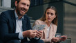 © Yuliia - Two business people in city Caucasian happy rich man businessman male masculine counting salary money sad woman female girl businesswoman frustrated with cash financial unequal rights injustice sexism
