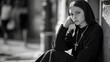 © Mads - A black and white photo of young nun, sitting on the street