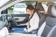 © KMPZZZ - Happy smile brunette asian young woman hand fastens a seat belt sitting in front of car before driving, vehicle for travel, trip take a safe journey, attractive driver with safety belt, transportation