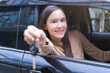 © KMPZZZ - Dealership automobile, smile asian young woman, happy girl sitting in new car after purchase success, showing, holding auto remote key of vehicle, owner driver female buy gift for yourself at showroom