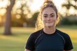 © SerPak - Young caucasian female in athletic wear smiling outdoors at sunset.