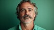 © Albert Kazakh - A middle-aged man with a prominent mustache stands confidently in front of a vibrant green backdrop. His expression conveys an aura of self-assuredness and approachability.