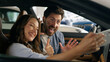 © Yuliia - Happy Caucasian couple make selfie photo picture mobile phone video call conference blog influencer thumb up smiling in auto woman girl female with man guy male in car automobile auto social media