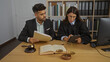 © Krakenimages.com - Man and woman working together in an office setting with law books, scales, and a gavel, showcasing collaborative efforts in a professional legal environment.