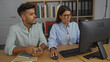 © Krakenimages.com - Woman and man working together in an office, focused on a computer screen, surrounded by bookshelves and office supplies, indicating a professional and collaborative work environment.