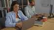 © Krakenimages.com - Woman and man working together on laptops in an office, both wearing headsets, surrounded by notebooks and a coffee cup, highlighting a productive workspace atmosphere.