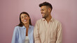 © Krakenimages.com - Couple smiling together standing against a pink background showing love and happiness in their relationship