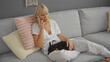 © Krakenimages.com - Mature blonde woman talking on phone in living room with chihuahua dog on her lap