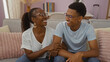 © Krakenimages.com - Mother and son sitting on couch smiling in living room showing love and bonding at home with glasses wearing casual clothes
