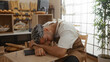 © Krakenimages.com - Tired man sleeping at a table in a bakery shop during working hours, surrounded by bread and pastries
