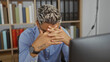 © Krakenimages.com - Young, arab, muslim man with beard feeling stressed at work in an indoor office setting
