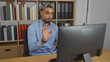 © Krakenimages.com - Handsome young arabian man with beard in an office interior, engaged in a professional video conference on a computer, showcasing a modern workplace setting.