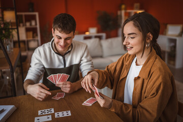 Wall Mural - young couple boyfriend and girlfriend play cards at home