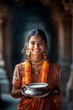 © Premium_art - Young South Asian woman in temple, smiles serenely holding a bowl.