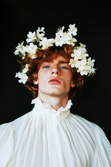 Wall Mural - A young man wearing a white shirt and a flower crown