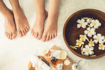 Wall Mural - Couple indulges in blissful foot massage at luxurious spa salon for reflexology therapy in gentle day light ambiance resort or hotel foot spa. Quiescent