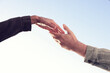 © New Africa - Man offering helping hand to his friend against blue sky, closeup