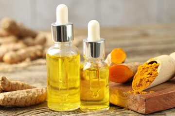 Canvas Print - Tumeric oil, powder and roots on wooden table, closeup