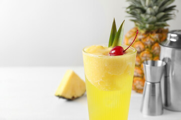 Canvas Print - Tasty pineapple cocktail with cherry in glass on light table, closeup. Space for text