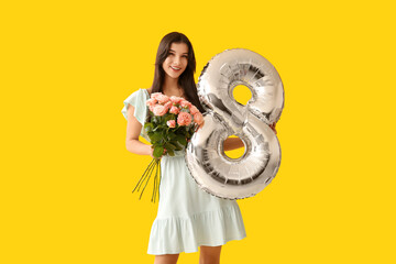 Wall Mural - Beautiful young woman with silver air balloon in shape of figure 8 and bouquet of pink roses on yellow background. International Women's Day