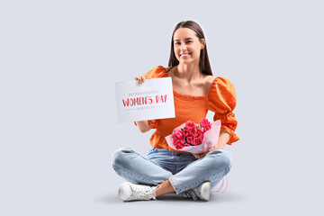 Wall Mural - Young woman with bouquet of tulips and greeting card on light background. International Women's Day