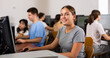 © JackF - Smiling female student using PC and studying computer science in the classroom