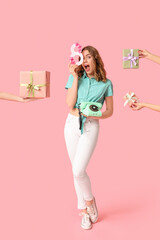 Wall Mural - Young woman with retro telephone, figure 8 made of paper and hands holding gift boxes on pink background. International Women's Day