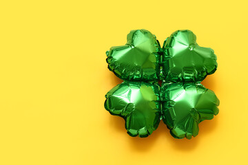 Wall Mural - Balloon in shape of clover on yellow background. St. Patrick's Day celebration