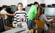 © JackF - Portrait of diligent interested teen schoolgirl ready for lesson in computer class, standing near table with workbook in hands..