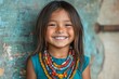© ChaoticMind - Young girl wearing colorful beads smiles brightly against a textured teal wall