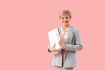 Poster - Mature businesswoman with folder on pink background