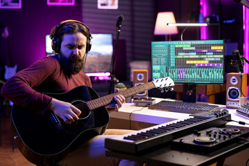 Poster - Artist recording his acoustic guitar tunes in home studio, using daw software interface on computer. Composer playing new string accords on musical instrument, acoustical engineering.